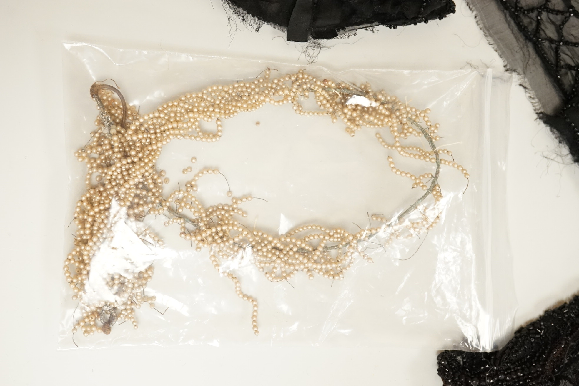 A cut steel fronter, a jet beaded panel, a pair of fringed black suede gauntlets, a seed pearl headdress, etc.